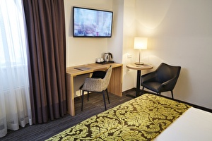 Amrâth Hotel Lapershoek Arenapark Comfort kamer met een bureau en een bed, ingericht voor comfort en functionaliteit.