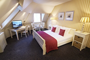 Amrâth Hotel Lapershoek Arenapark Junior Suite king size bed, rood sprei met rode kussentjes, geel gestreept muurbekleding en een tv met zithoek