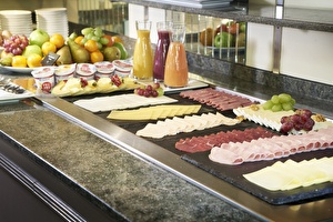 Amrâth Hotel Lapershoek Arenapark restaurant Vivaldi breakfast buffet, platter with cold cuts, cheese, sausage, and brie, platter with fruit, apples, grapes, juices, and yogurt.