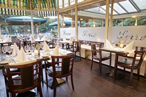 Amrâth Hotel Lapershoek Arenapark restaurant Vivaldi with set tables with white napkins and wooden chairs.