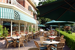 Amrâth Hotel Lapershoek Arenapark terrace adjacent to restaurant Vivaldi. Parasols are unfolded above the tables and chairs on the terrace.