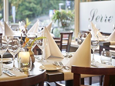 A restaurant with white tablecloths and napkins, creating an elegant and sophisticated atmosphere for dinners.