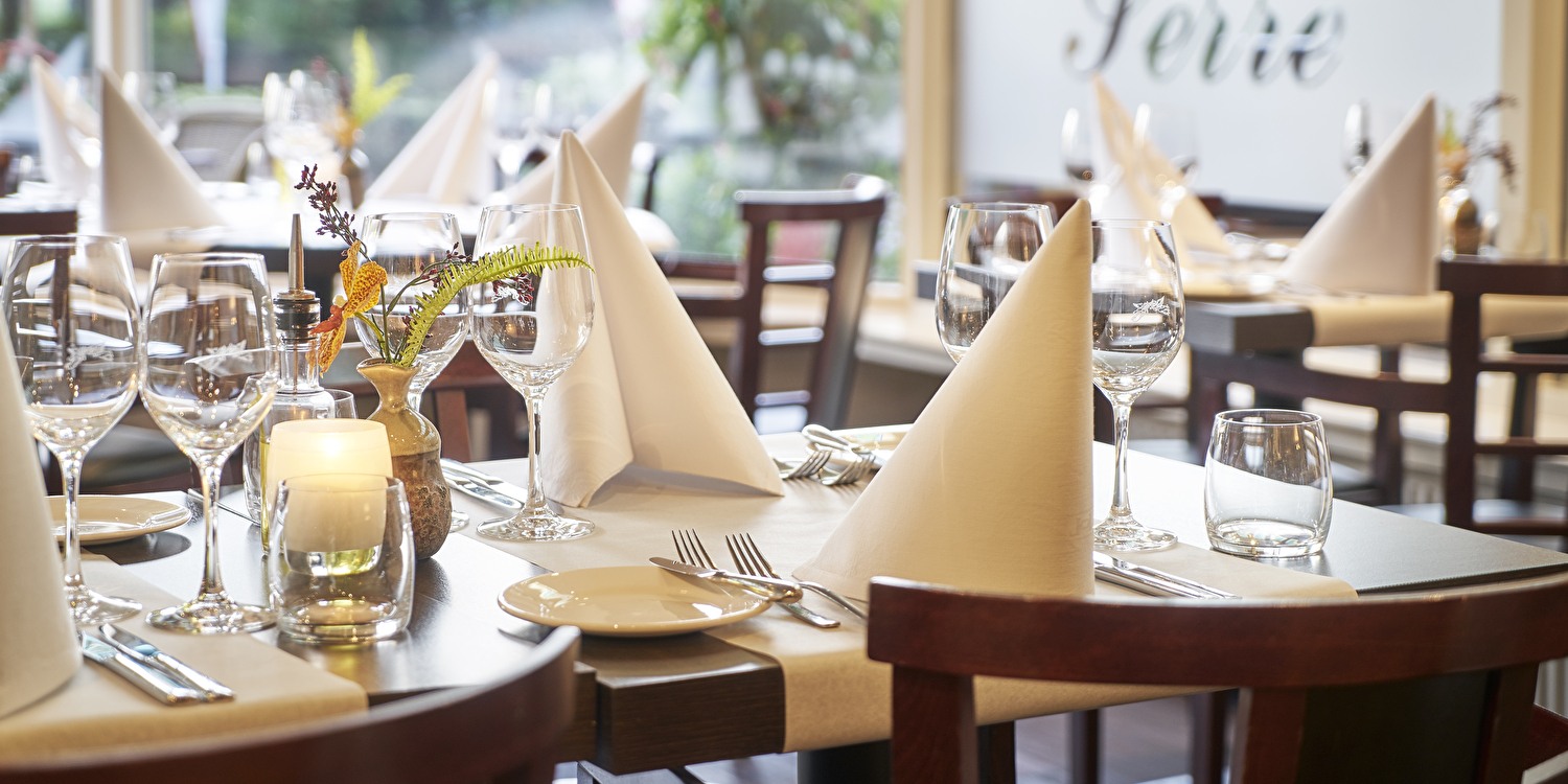 Restaurant Vivaldi, tafel is gedekt met witte tafelkleden en witte servetten.